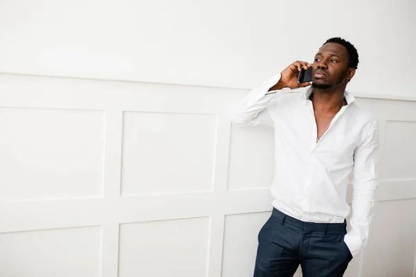 Portret Afroamerykanina biznesmena w rozpiętej koszuli, rozmawiającego przez telefon ze swoim prawnikiem w jasnym pokoju — Zdjęcie stockowe