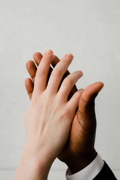 United hands white-skinned Europeans and dark-skinned African American. The symbol of and struggle against oppression. — Stock Photo, Image