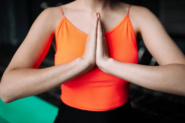 Close-up borst van een yoga trainer die voor haar handpalmen houdt in een gebed gebaar in de sportschool — Stockfoto