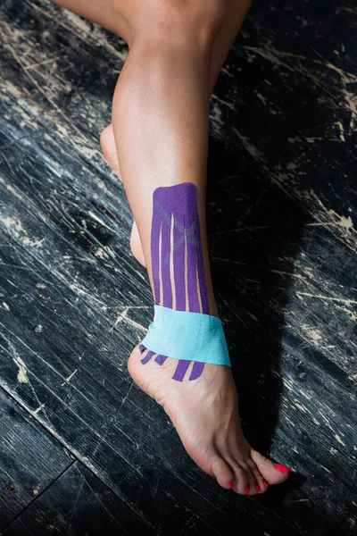Woman\'s leg with kinesio patch on ankle and foot