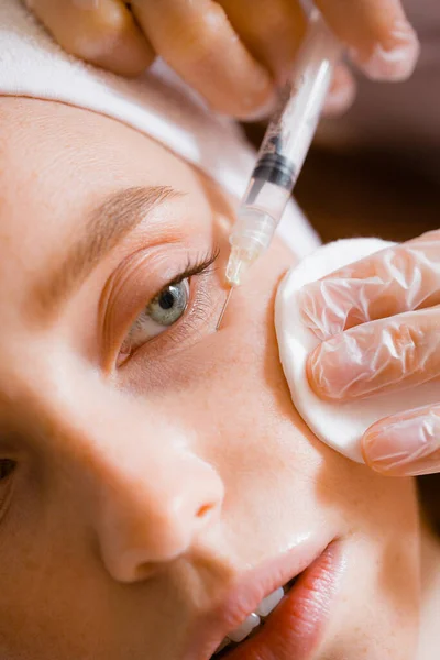 Portrait of a red-haired girl at a beautician's reception. Syringe, needle — Stock Photo, Image