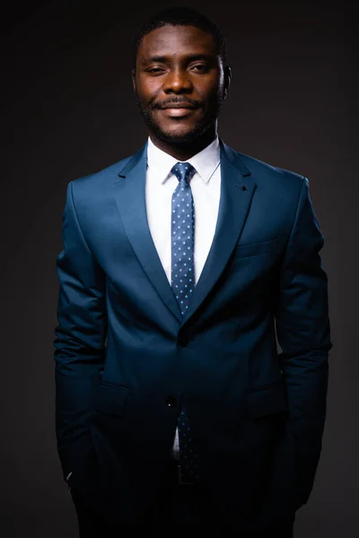 Retrato de um homem de negócios afro-americano de terno clássico azul que fica em fundo cinza — Fotografia de Stock