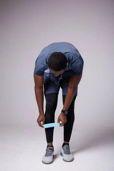 Αρσενικό γυμναστή βάζει λάστιχο στο πόδι του για προπονήσεις — Φωτογραφία Αρχείου
