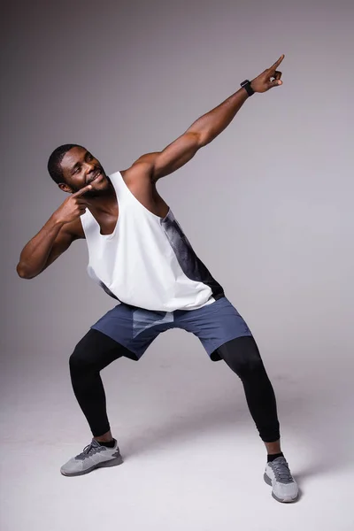 Μαύρος αθλητικός τύπος που κάνει dab μπράτσα χειρονομία σε γκρι φόντο στούντιο, αστείο αφρικανός τύπος dabbing κινείται στο διαδίκτυο meme θέτουν έννοια θρίαμβος. — Φωτογραφία Αρχείου