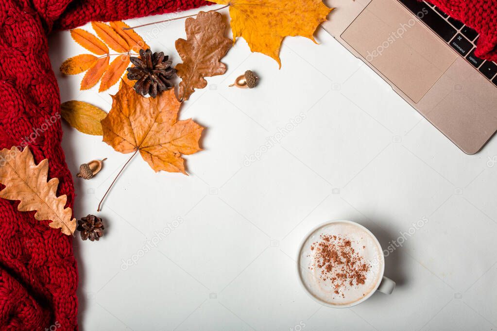 The concept of a cozy workplace in the fall. Coffee, laptop, red plaid and autumn leaves. Flat lay