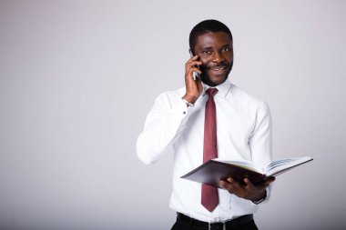 Bir adam elinde açık bir evrak klasörü tutuyor ve telefonda konuşuyor. Karantinada uzaktan çalışma kavramı