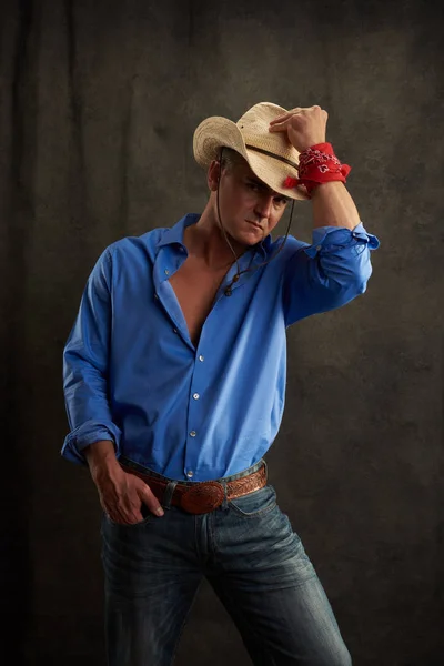 The sexy cowboy poses for the camera.