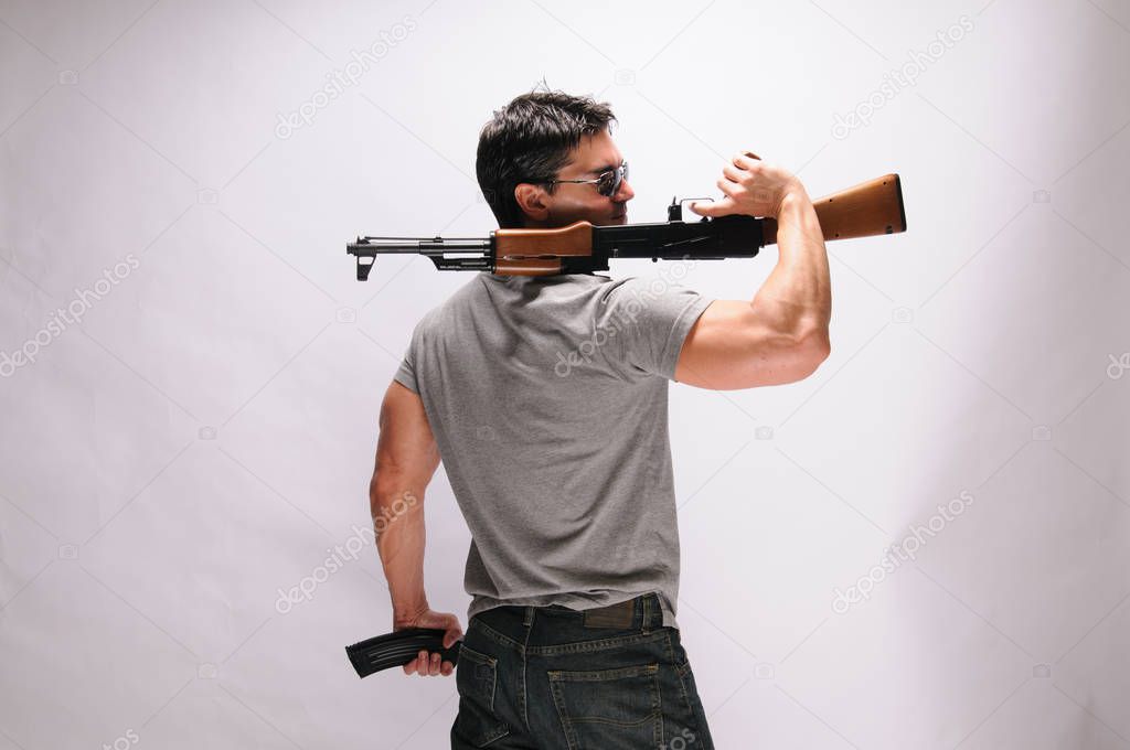 The sexy man holds onto a rifle