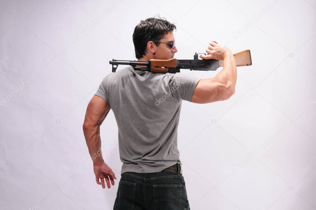 The sexy man holds onto a rifle