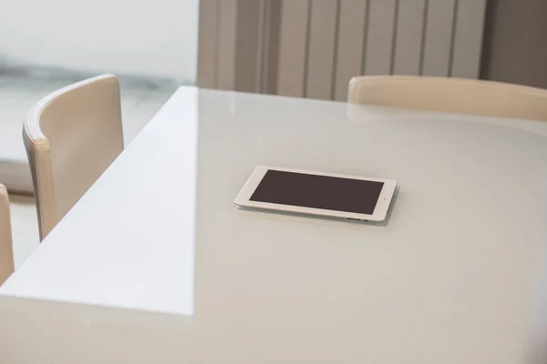 Beyaz masadaki siyah ekranlı beyaz tablet