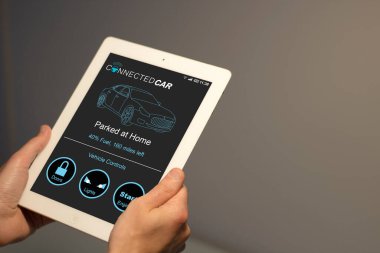 Ekranda bağlı araba uygulaması olan bir adamın elleri tableti tutuyor