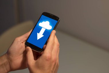 Ekranda bulut indirme simgesi olan cep telefonunu tutan adamın ellerini kapat.