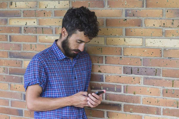 Portrait Young Man Leaning Brick Wall Checking His Smartphone — Stock Photo, Image