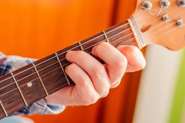 Genç bir adamın elektro gitar çalarkenki görüntüsü. Müzik, enstrüman eğitimi, öğrenme kavramı