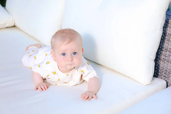 Χαριτωμένο Κοριτσάκι Ξαπλωμένο Λευκό Καναπέ Κοιτάζοντας Την Κάμερα Όμορφα Μπλε — Φωτογραφία Αρχείου