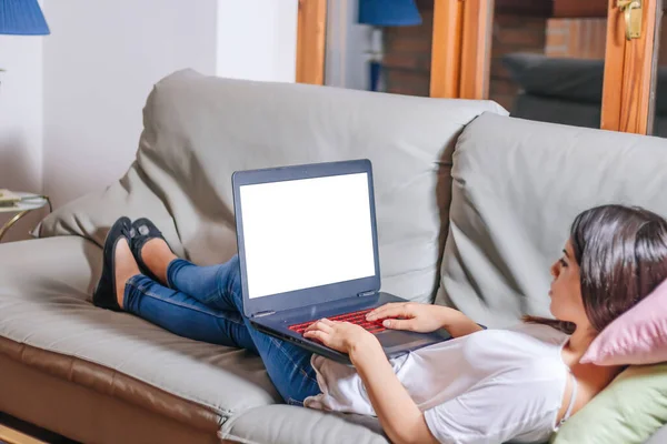 Jovem Deitada Confortavelmente Sofá Enquanto Usa Laptop Com Tela Branco — Fotografia de Stock