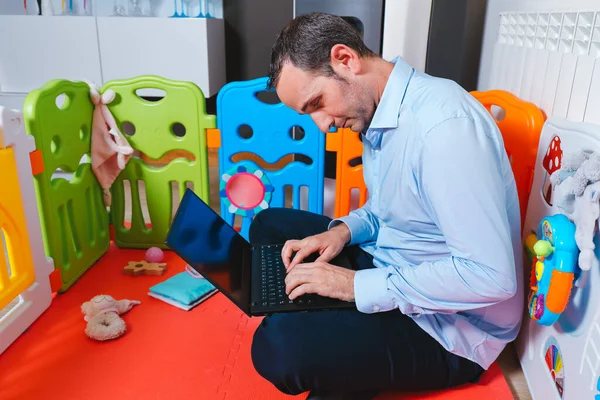 Genç iş adamı bebeğinin oyun parkında uyuya kaldı. Evden çalışma ve fazla mesai konsepti