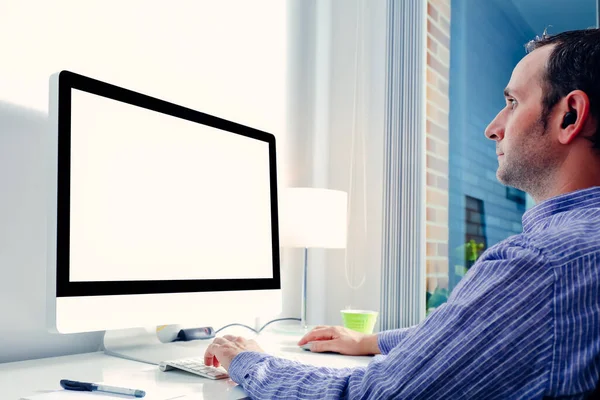 Ofis masasında boş ekranla çalışan genç bir iş adamı. Bilgisayar ekranı maketi. Boşluğu kopyala