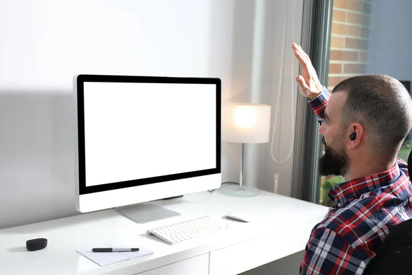 Sanal buluşma konsepti. Genç adam merkez ofisten kameraya el sallıyor. Bilgisayar ekranı maketi. Boşluğu kopyala