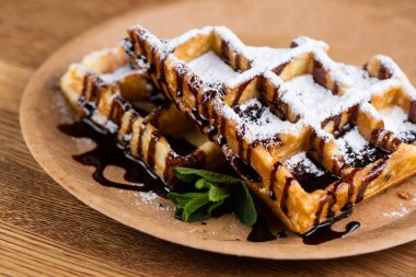 Tek kullanımlık tabakta Viyana waffle 'ı, sıvı çikolata, şeker ve nane şekeri..