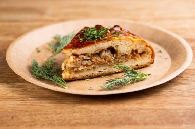 Haşlanmış lahana turtası ve tek kullanımlık tabakta otlar serpiştirilmiş havuçlar.