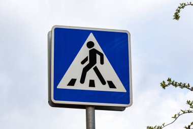 Gökyüzü arka planında yaya geçidi işareti.