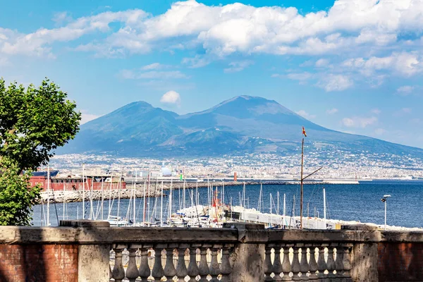 Napoli, Campania, İtalya - 24 Haziran 2019: Napoli seddindeki ünlü Vezüv Dağı manzarası. Beyaz bulutlu mavi gökyüzü, yaz güneşli günü.