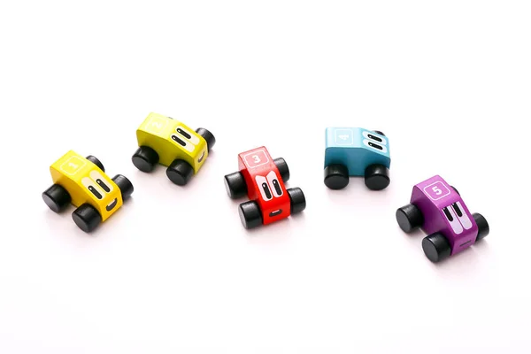 Brinquedos educativos para crianças. Carros de madeira coloridos com números no fundo branco — Fotografia de Stock