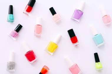 Beyaz arkaplanda farklı renkte tırnak cilası grubu