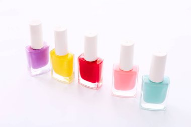 Beyaz arkaplanda farklı renkte tırnak cilası grubu