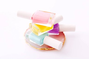 Beyaz arkaplanda farklı renkte tırnak cilası grubu