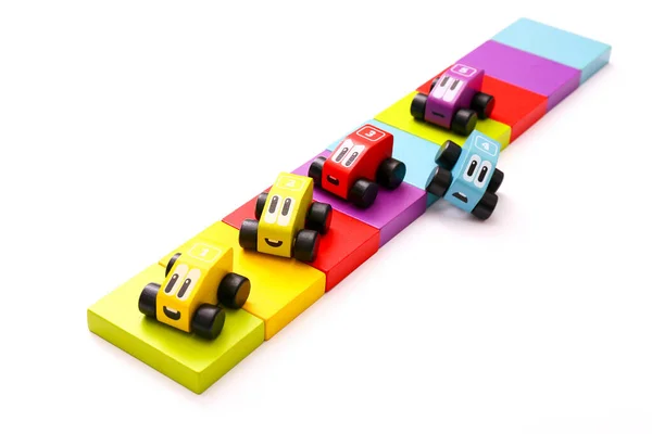 Brinquedos educativos para crianças. Carros de madeira coloridos com números no fundo branco . — Fotografia de Stock