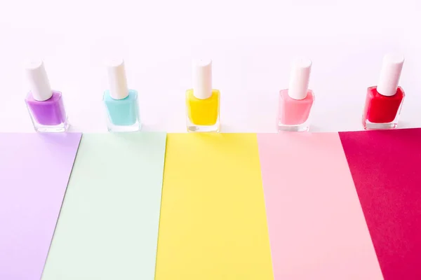 Gruppe von Nagellacken in verschiedenen Farben auf buntem Hintergrund. — Stockfoto
