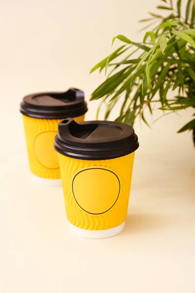 Tazas de café desechables de papel corrugado con tapa sobre fondo beige, dos tazas en fila — Foto de Stock