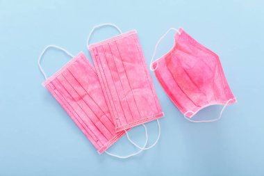 Pastel mavi arka planda pembe tıbbi koruyucu maskeler, üst manzara, düz yatış