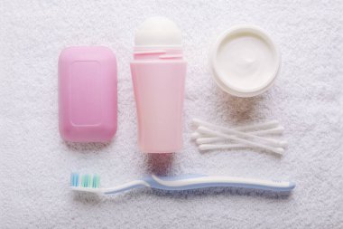 Beyaz havlu arka planında banyo aksesuarları, üst görünüm