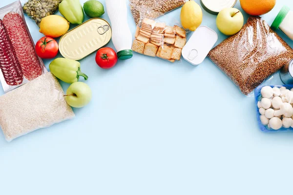 Conjunto de itens de supermercado de alimentos enlatados, legumes, cereais em fundo azul. Conceito de entrega de alimentos. Conceito de doação. Vista superior. — Fotografia de Stock