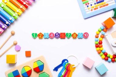 Beyaz arka planda renkli çocuk oyuncakları. Üst manzara, düz uzanma.