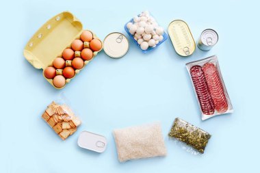 Konserve yiyecekler, sebzeler, mavi arka planda mısır gevreği. Yemek teslimatı konsepti. Bağış konsepti. Üst görünüm.