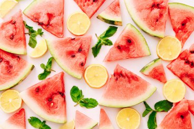 Nane yapraklı karpuz parçaları ve beyaz arka planda limon dilimleri. Düz yatış, üst görünüm
