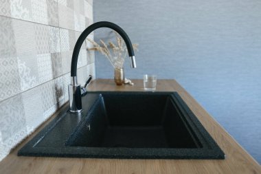 Mutfakta siyah mutfak lavabosu ve musluk suyu var. Mutfak Aletleri. Ev Aletleri