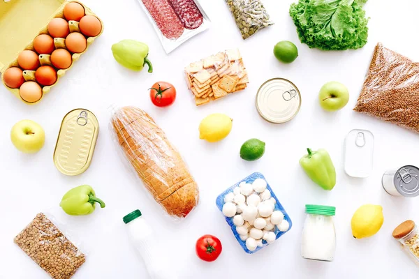 Set of grocery items from canned food, vegetables, cereal on white background. Food delivery concept. Donation concept. Top view.