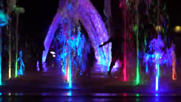 Silhouetten Rennender Und Jubelnder Kinder Vor Dem Hintergrund Farbiger Springbrunnen — Stockvideo