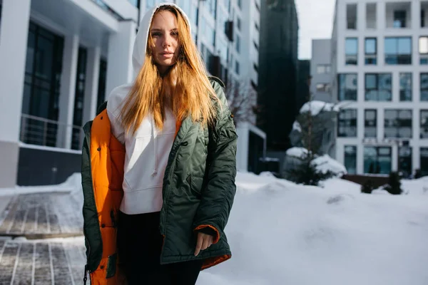 Portrait of blonde woman in hood and jacket against winter day — Stock Photo, Image