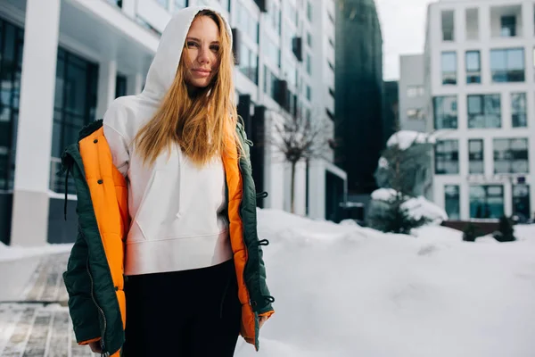 Bild des blonden Mädchens mit Kapuze und Jacke gegen den Wintertag — Stockfoto