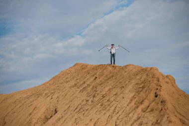Eller yukarı ile uzaktan ile erkek turist fotoğraf tepe üzerinde yürümek için sopa