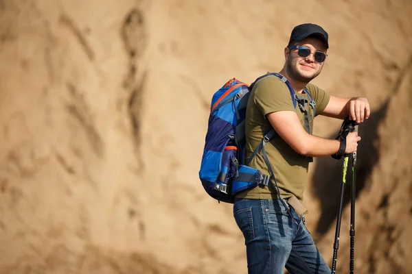 Photo of sports man with backpack and walking sticks — Stock Photo, Image