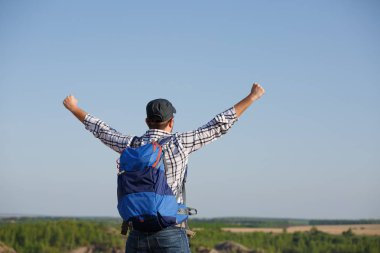 Fotoğraf arka sırt çantası, eller yukarı tepe dağ expanses, mavi gökyüzünün arka planda üzerinde turist adam