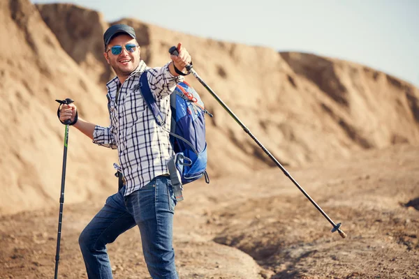 Picture of tourist man pointing stick for walking forward on hill
