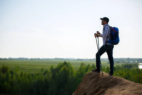 Afbeelding van toeristische man met stokken voor lopen op hil — Stockfoto